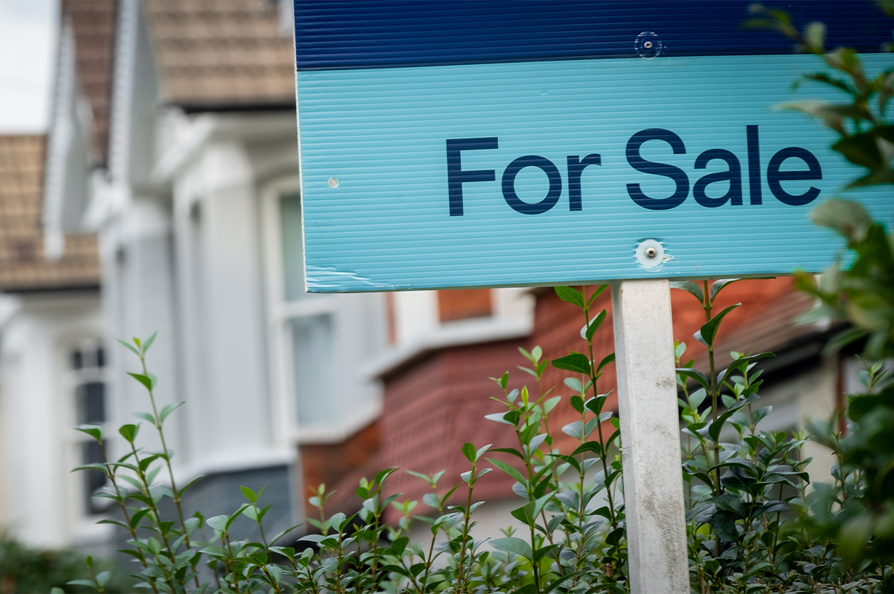 a for sale sign outside a british terraced house